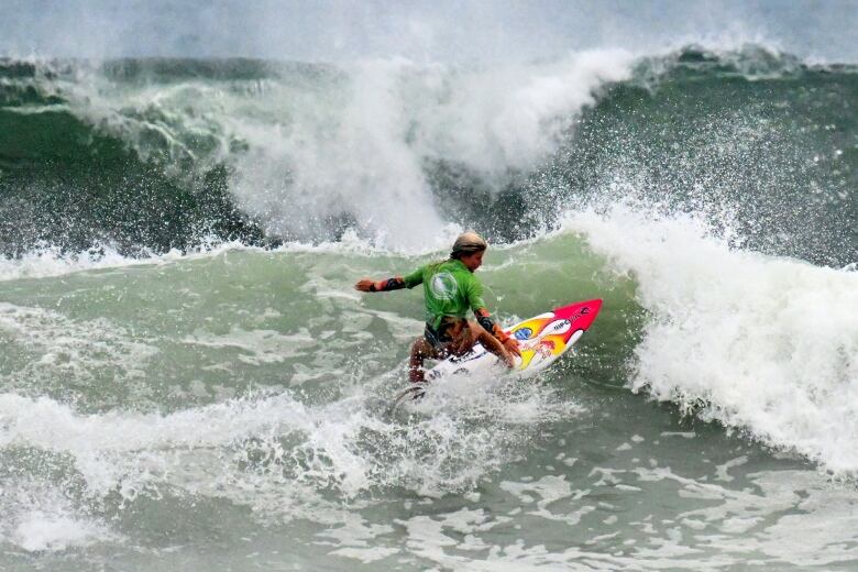 A teenager surfs.