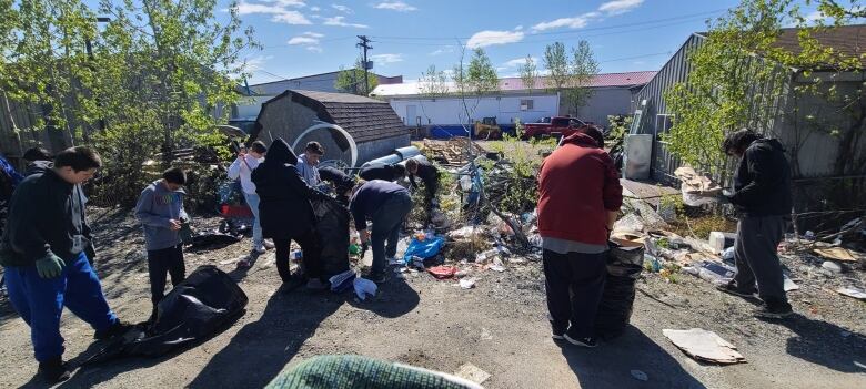 A group of preteens pick up garbage.