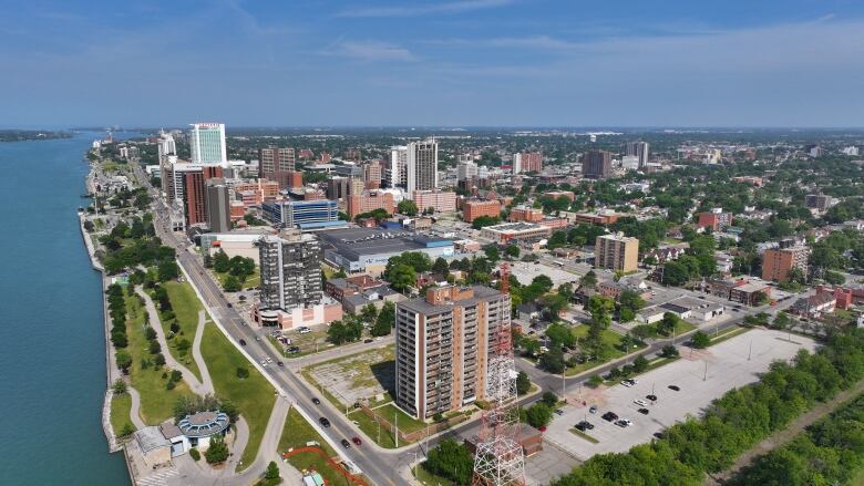 An aerial image of a city skyline and the Detroit River.