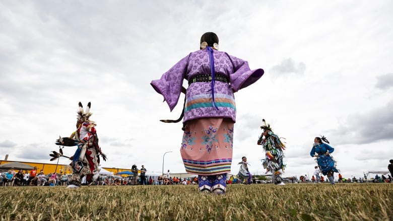 Powwow dancers perform while wearing traditional First Nations regalia. 