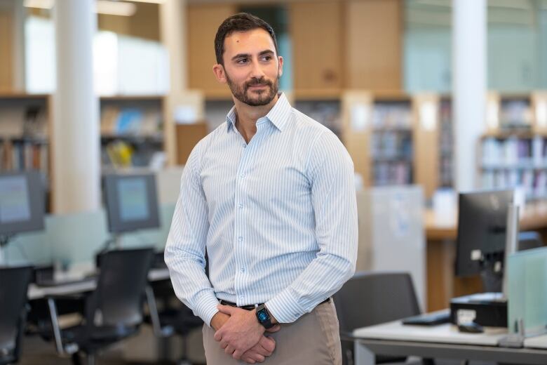 A man stands in a library.