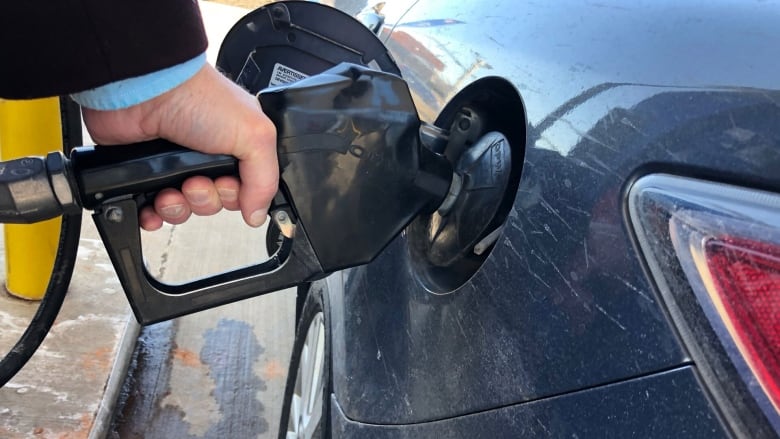 A driver fills car at gas station. 