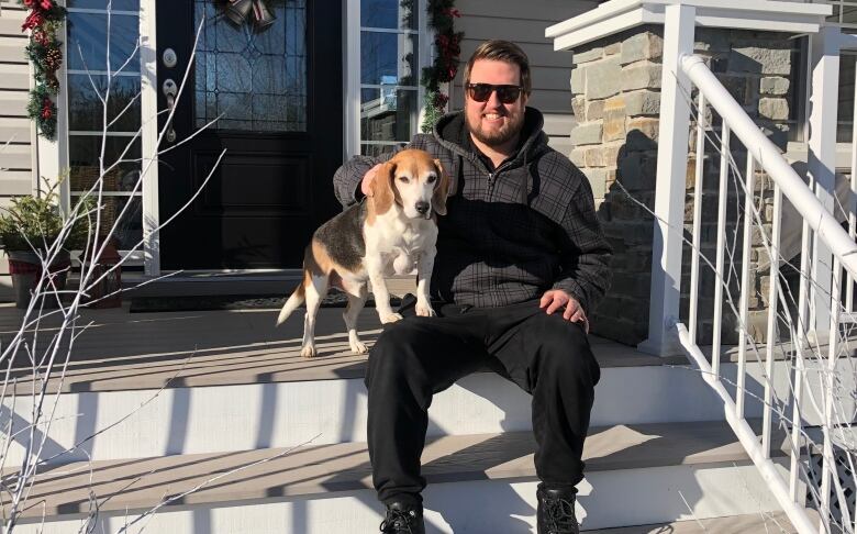 Ryan is sitting on the steps outside the front door of his parents house.