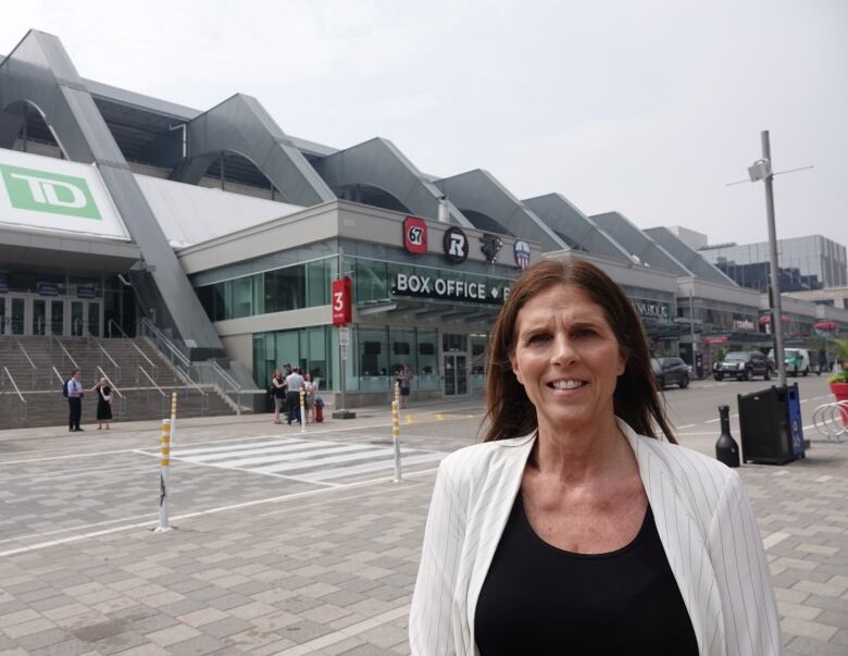 A sports company executive poses outside a stadium.