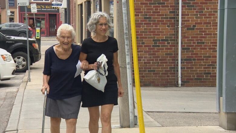 Two woman walk toward the camera.