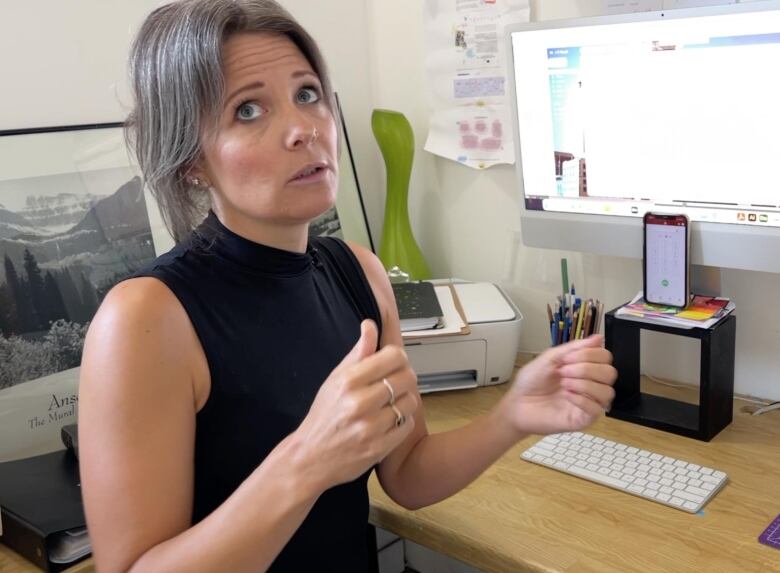 Tessa Rei Lerbekmo-Joyes sits at her desk and is about to make a call to the Video Relay Service.