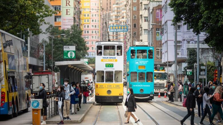 A busy cityscape with people and streetcars.