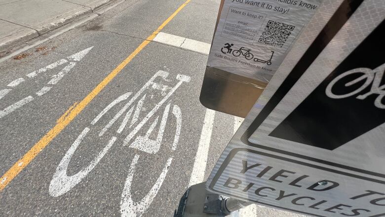 A bike lane and a sign are pictured.