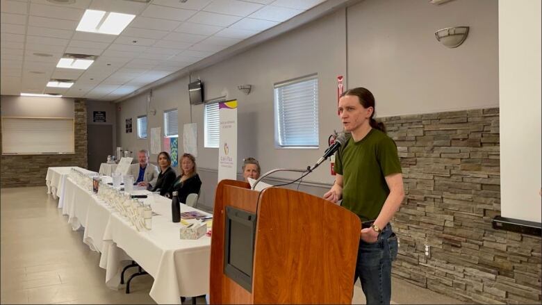 Someone speaks at a lectern in a meeting room.