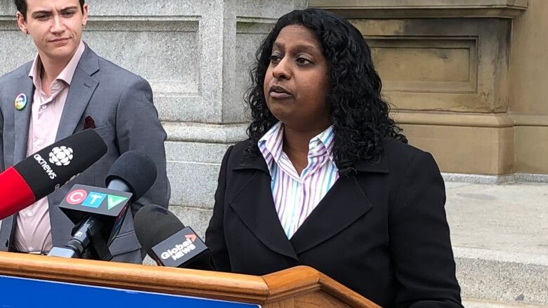 Woman speaking at podium with a sign saying Canadian Civil Liberties Association in front. 