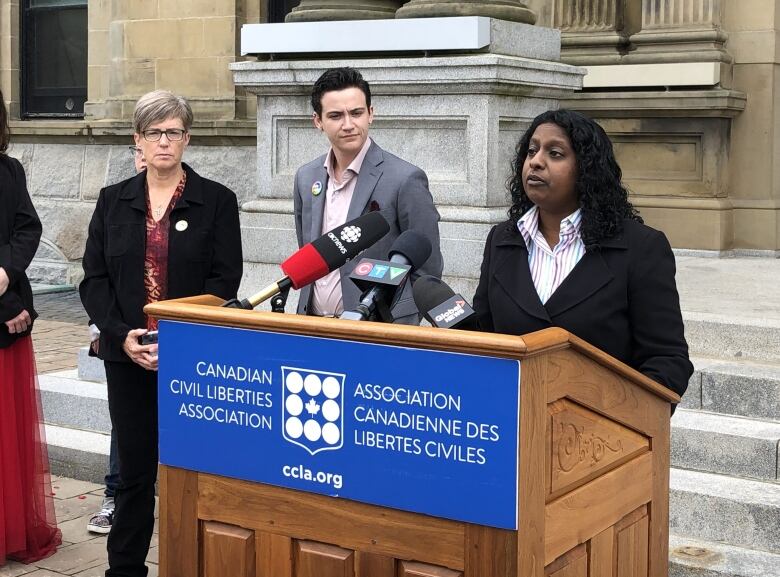 Woman speaking at podium with a sign saying Canadian Civil Liberties Association in front. 