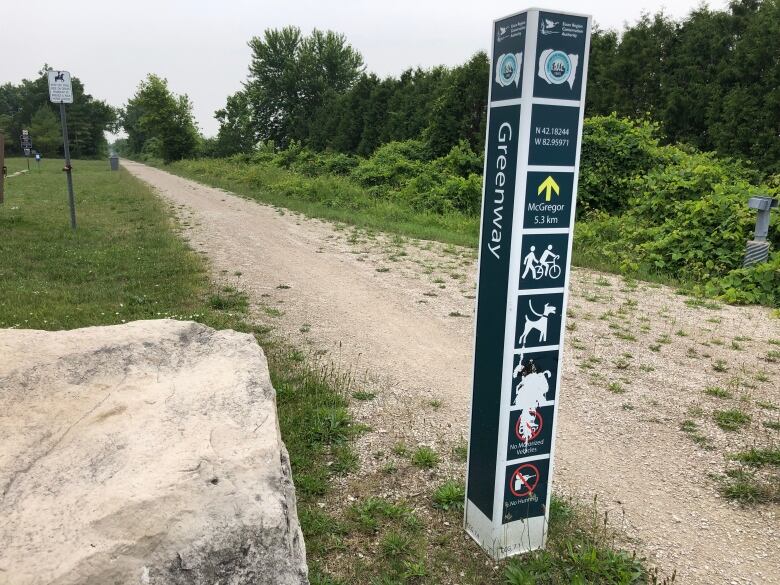 A dirt trail with a directional signpost that says 