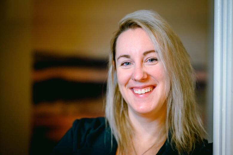 A woman with blonde hair wearing a green shirt. 