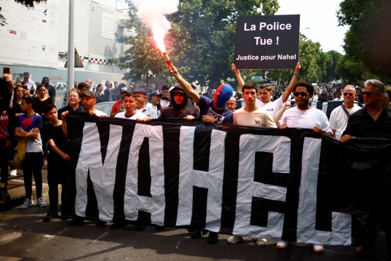 People carrying a banner take part in a march. 