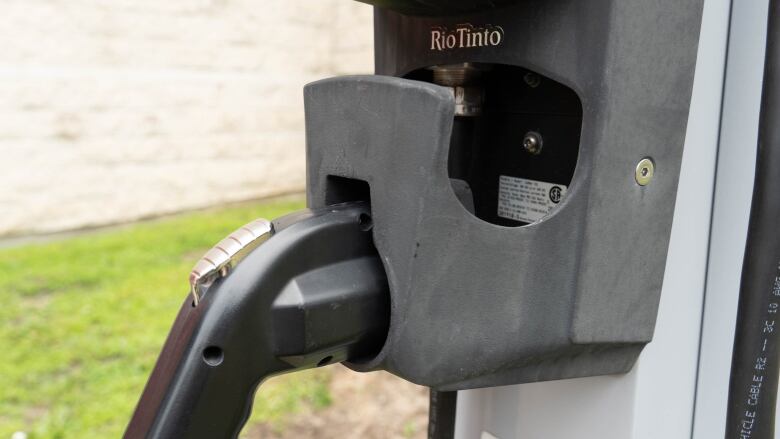 A grey plastic handle that plugs into an electric car