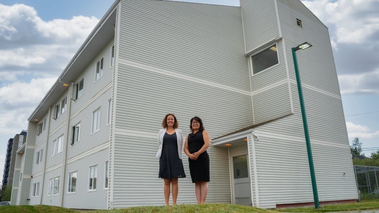 Yellowknife Mayor Rebecca Alty, and N.W.T. Housing Minister Paulie Chinna stand in front of the Aspen Apartments in downtown Yellowknife on June 30, 2023.