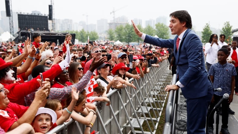 A man waves to the crowd.