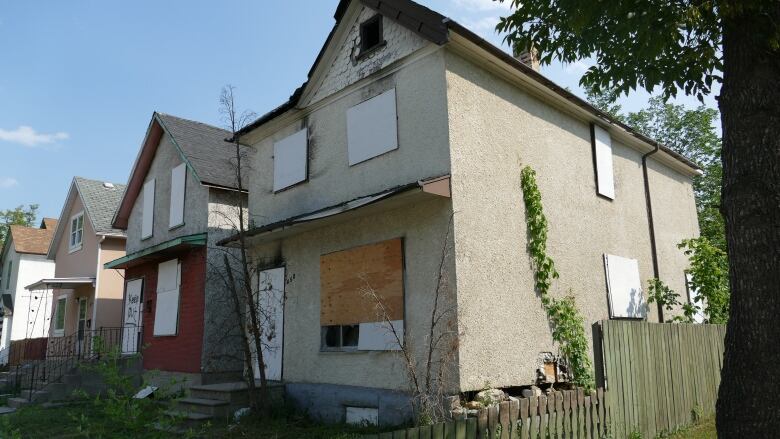 The windows of a home on Elgin Avenue are boarded up.