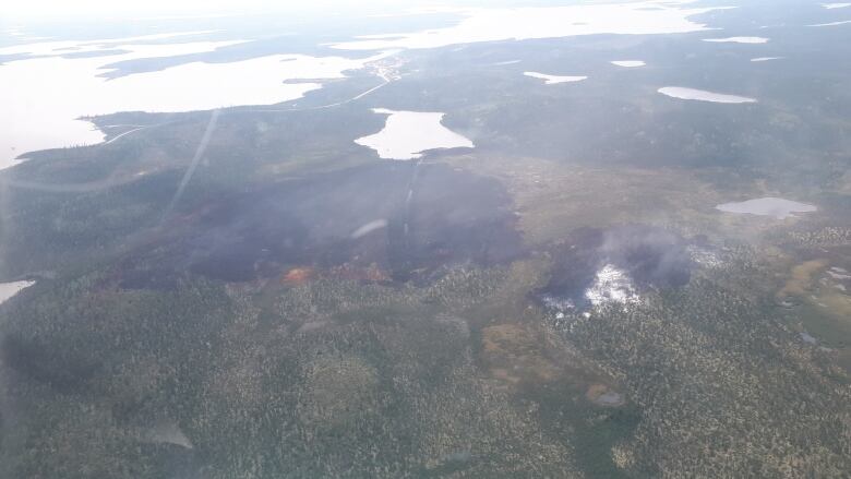 a view of the ground from an airplane with a burn area