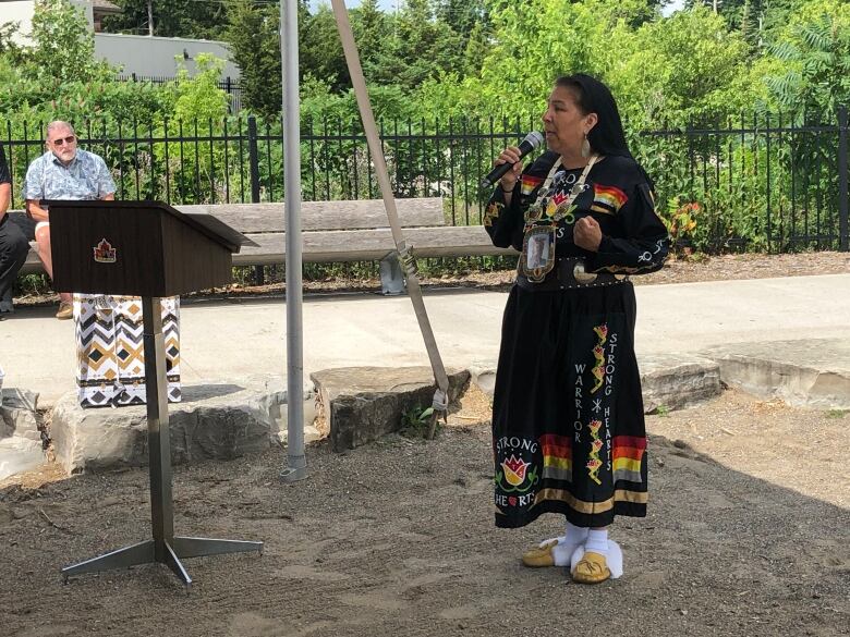 A woman speaks into a microphone. 