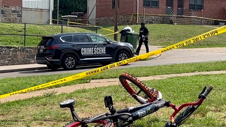 A bike rests on a lawn at a crime scene.