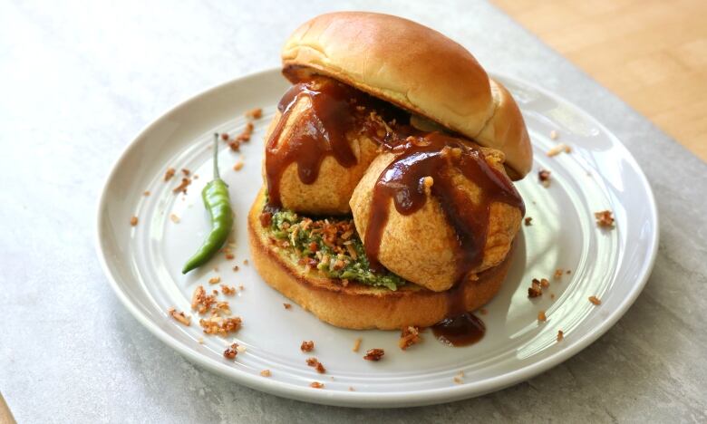  Potato fritters with ketchup, chutney, and spices on buns.