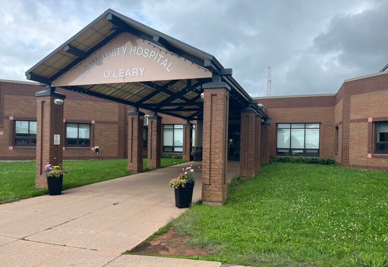 A brick walkway leads into the front doors of a rural hospital.