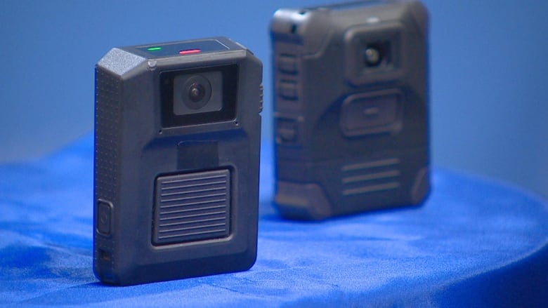 Photo of two retangular cameras slightly bigger than the size of a hand.