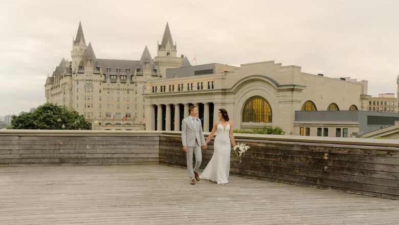 A wife and groom pose for a wedding photo, with smoky skies in the background.