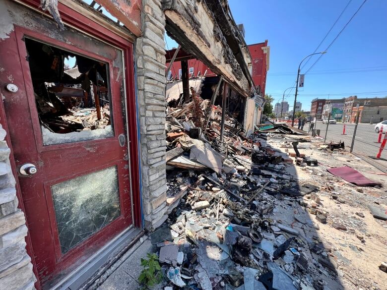 The exterior of a brick building that's been heavily damaged by a fire. 