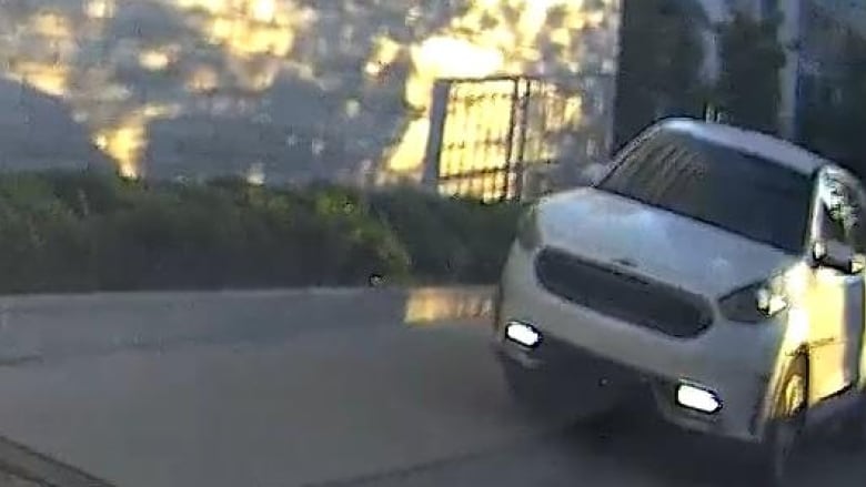 A white Kia Niro parks outside a ramp in a loading area.