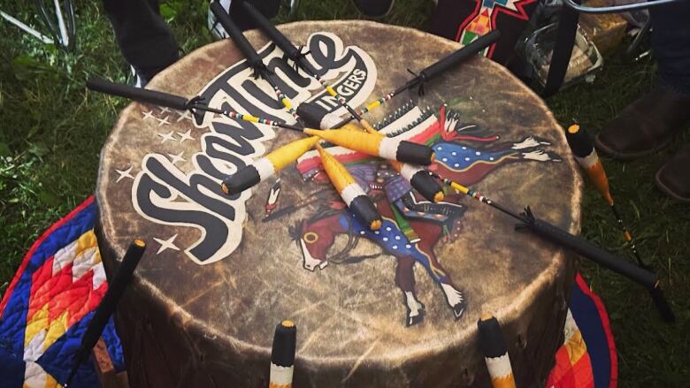 A drum with the words 'Show Time' written across it, along with a painting of a man on a horse.