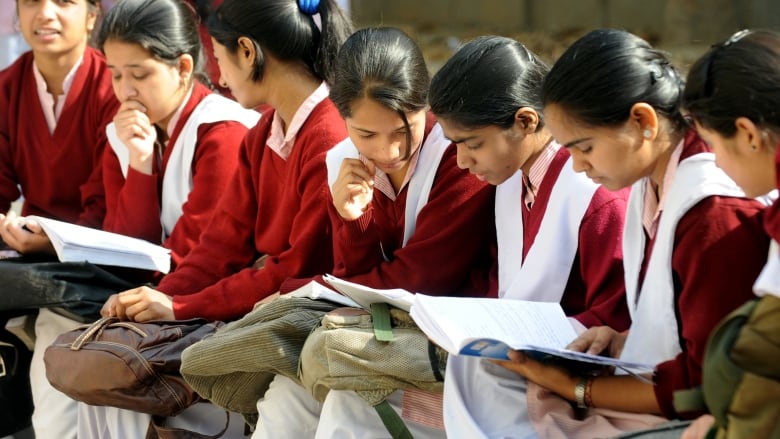 Indian school children consult their textbooks last minute as they prepare for their Central Board of Secondary Education (CBSE) examinations in New Delhi on March 1, 2012. 