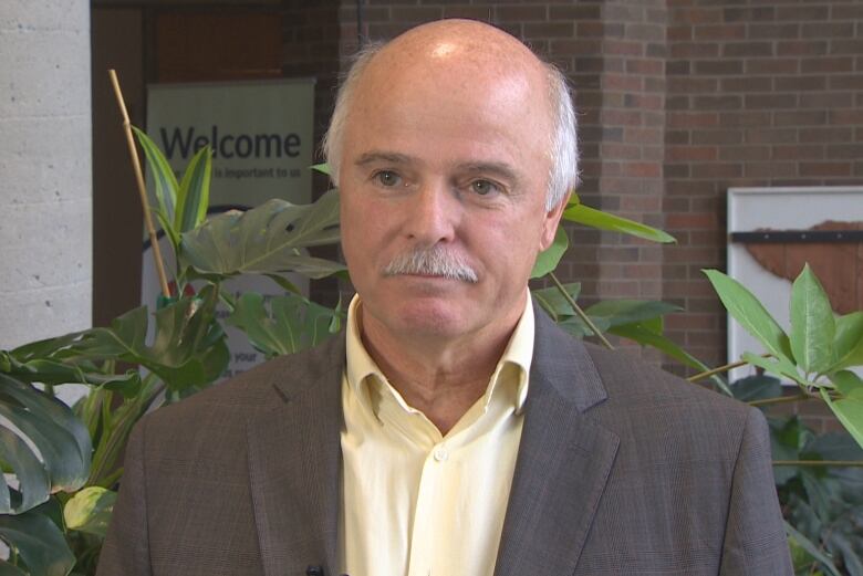 A man in his fifties wearing a suit stands in the lobby of a government building in Newfoundland and Labrador.