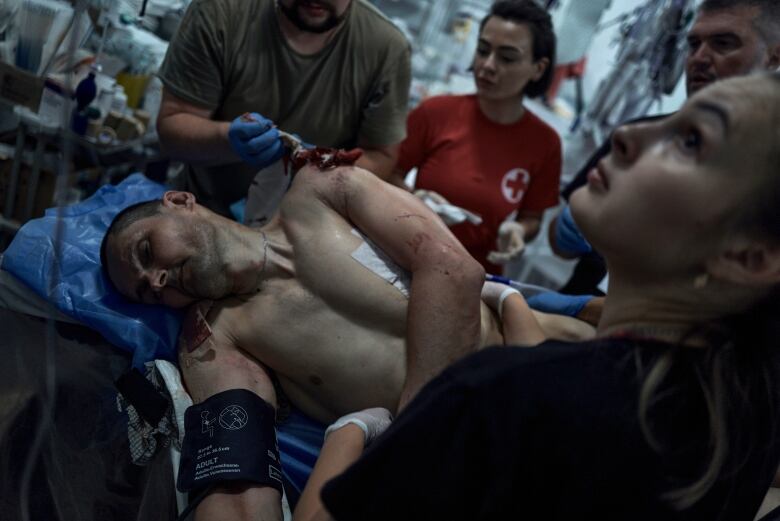 Ukrainian military medics give first aid to a wounded soldier in a stabilization point on the frontline near Bakhmut, Donetsk region, Ukraine on July 4 2023.