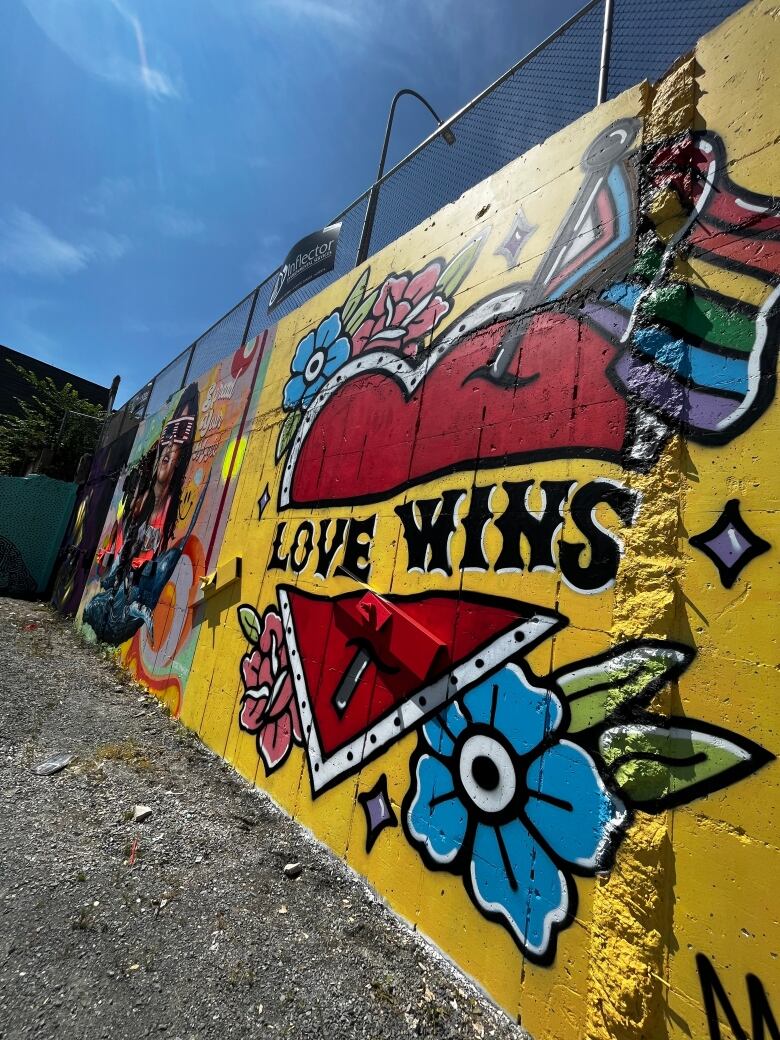 A mural showing a red heart symbol on a yellow background with 