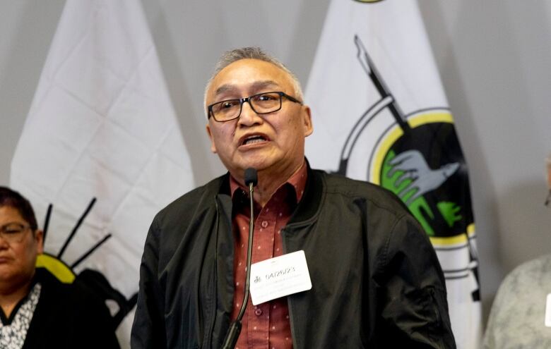 A man speaks at a microphone during a press conference.