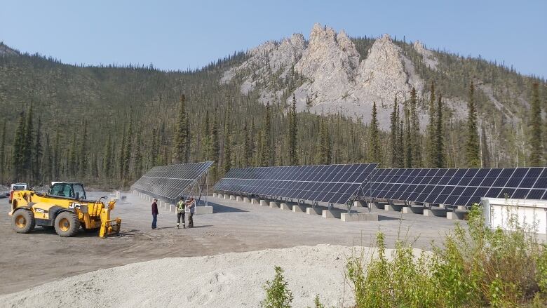 Solar arrays infront of a mountain.