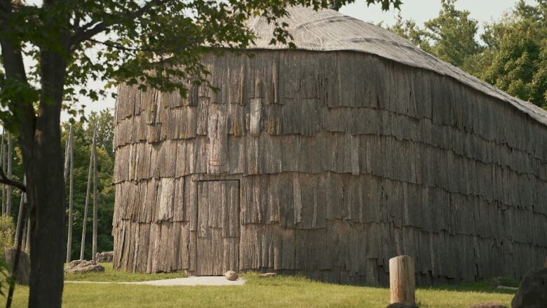 A wooden longhouse takes up most of the frame.