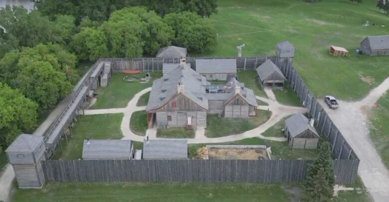 An aerial photo shows a wooden fort, surrounded by a wood pallisade.