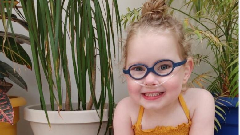 Photo of five-year-old Rylee Warkentin smiling with an oxygen tube and blue glasses.