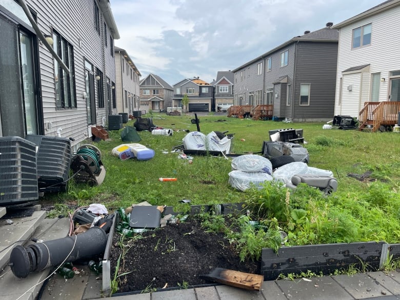 Household debris in a common yard between homes after a windstorm.