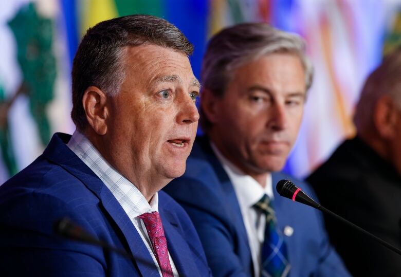 Tim Houston, vice-chair of the Council of the Federation and premier of Nova Scotia (right), listens in as Prince Edward Island Premier Dennis King speaks to media during the closing news conference at the Council of the Federation Canadian premiers' meeting at The Fort Garry Hotel in Winnipeg on July 12, 2023.