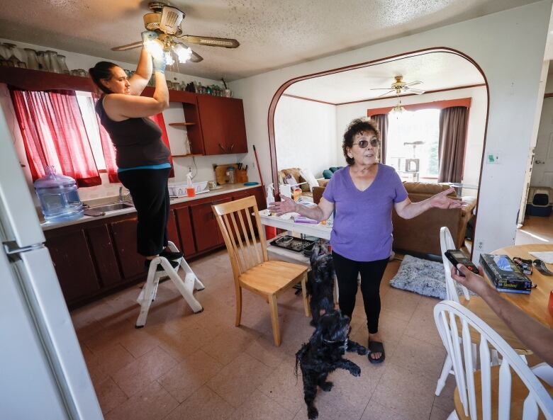 A woman stands in a kitchen.