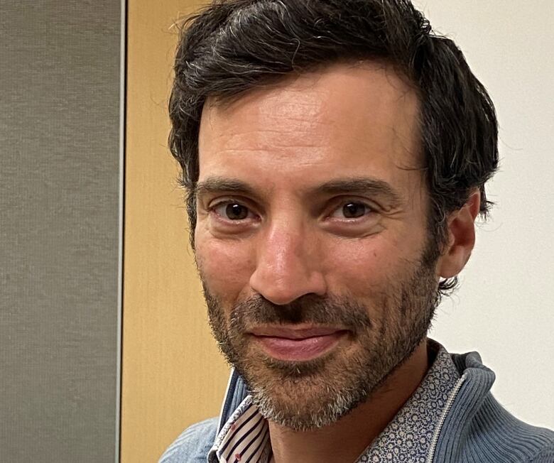 A man with short brown hair and close-shaved facial hair. 