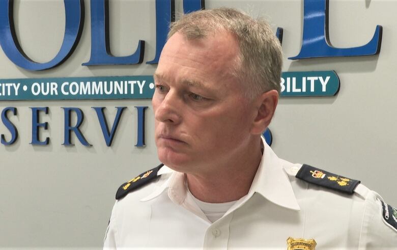 Brad McConnell in uniform in front of police logo.