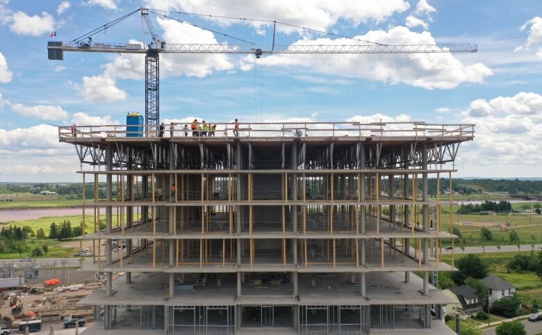 Construction workers are seen atop a residential building under construction in Moncton, N.B., in the summer of 2022.