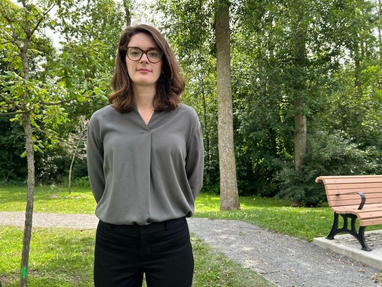 A woman stands in a park.