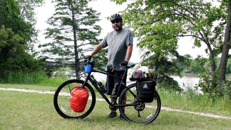 A man stands next to his bike