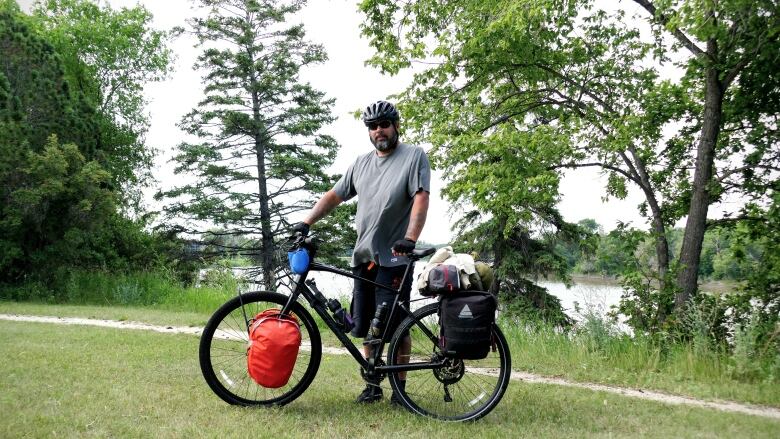 A man stands next to his bike